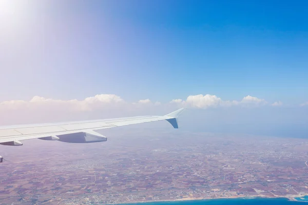 Wing passenger aircraft during the flight on the background of clouds