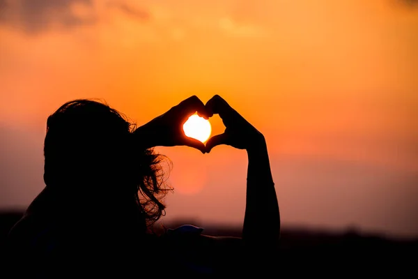 Una Chica Hace Corazón Silueta Con Los Dedos Una Puesta — Foto de Stock