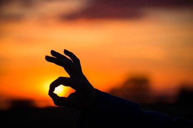 El işareti iyi veya Ok parmak gün batımı veya gün doğumu, başarı kavramı