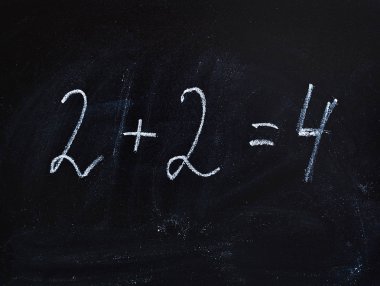 2 artı 2 eşittir 4 kara bir tahta üzerinde tebeşir le yazılmış