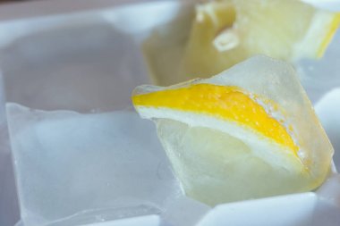 Bir buz parçasında dondurulmuş limon dilimi
