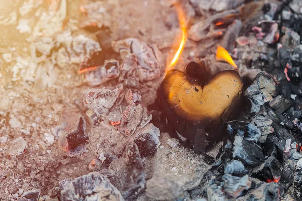 Wooden heart in fire and coals
