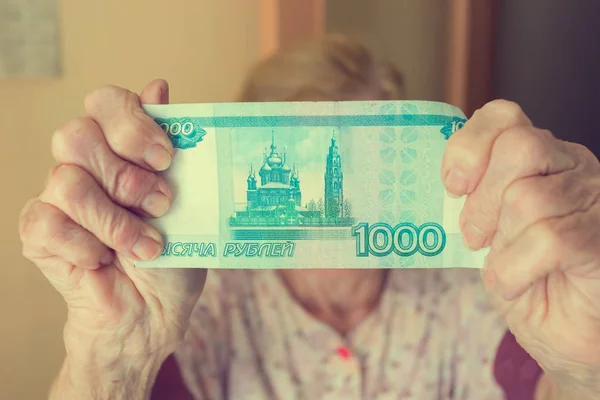 De hand van een oudere vrouw met geld. Roebels van gepensioneerde. — Stockfoto