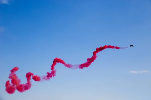 Vliegtuigen met gekleurde Smoke Trail op de achtergrond van Blue Sky — Stockfoto