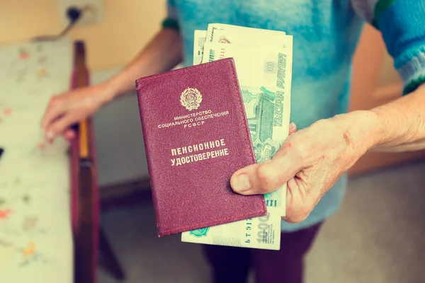 Пенсионное удостоверение в руках пожилой женщины — стоковое фото