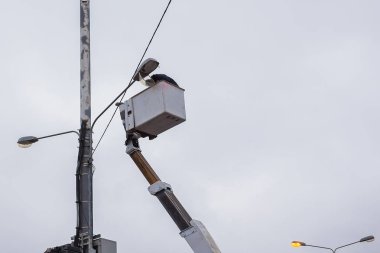 Moskova, Rusya - 19 Kasım 2018: Öğleden sonra sokaktaki bir sütunda yüksek katlı bir platformda aydınlatma lambasının onarımı üzerinde yüksek katlı çalışmalar