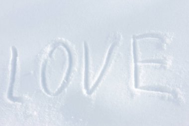 Beyaz pofuduk kar üzerinde aşk kelimesi