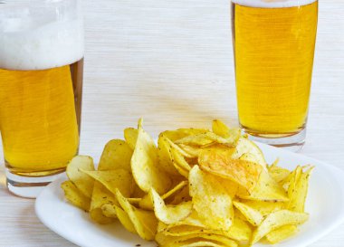 Tabakta patates cipsi ve bira. 