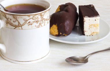 Beyaz bir tabak ve sıcak çay fincan lezzetli bir tatlı.