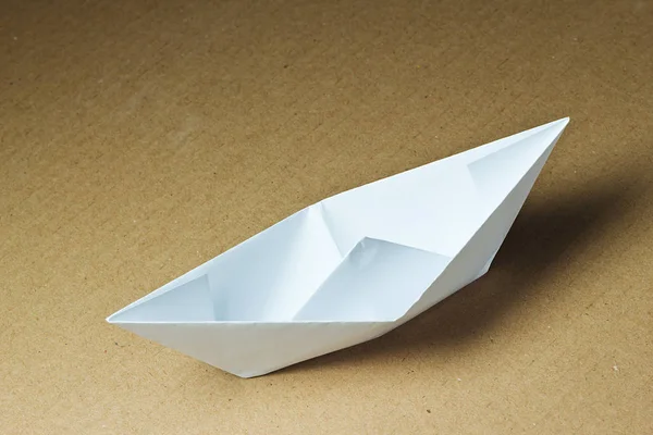 stock image Paper boat on cardboard background