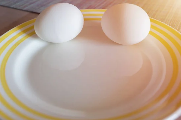 Two eggs in a shell for Breakfast on a plate