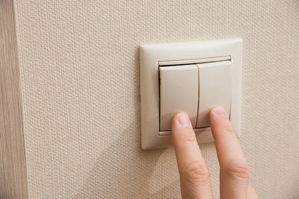 Men's hand and wall light switch