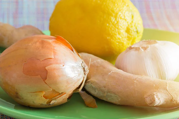 Onions,, Garlic,  ginger and lemon on a plate, the best folk ways to treat flu and colds