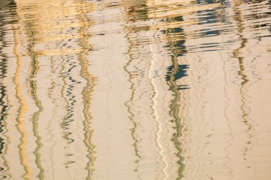 Denizlerdeki yat ve gemilerden gelen beyaz direklerin yansıması.