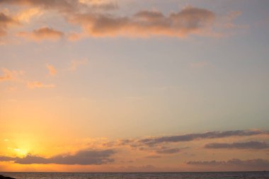 İtalya 'nın Sicilya kentindeki Cefalu şehrinde gün batımında güneş ışınları denizin üzerinde bulutları delip geçer.