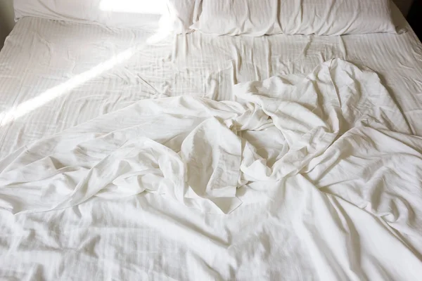 crumpled white sheet in bed