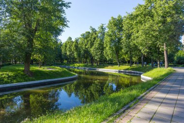 Trubetskoy Parkı ve Moskova 'nın Frunzenskaya metro istasyonu yakınlarındaki Khamovniki bölgesinde güneşli bir yaz gününde ağaçlar ve gölet.