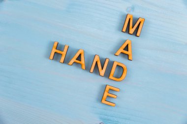 El kelimesi ahşap tahtalardan yapılmış mavi doğal arka planda bulunan ahşap harflerden yapılmıştır.