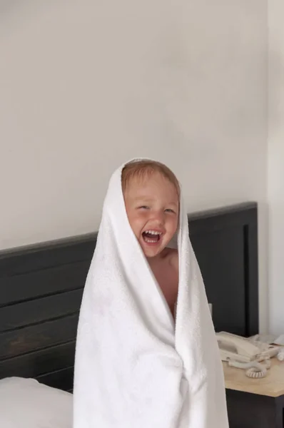 The little girl in the towel is smiling. — Stock Photo, Image