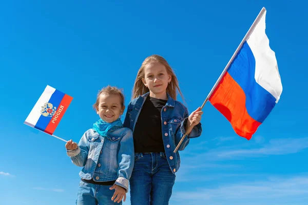 Bambini felici, ragazze carine con la bandiera della Russia contro un cielo blu chiaro . — Foto Stock