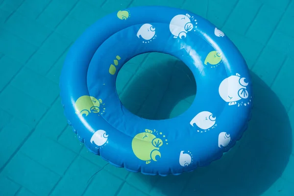 Голубое резиновое кольцо лежит в бассейне в саду. Концепция — стоковое фото