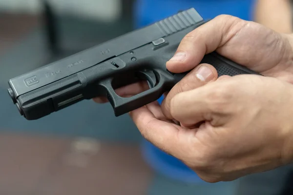 Una mano de hombre practicando el disparo usando un modelo de pistola Glock en el campo de tiro. Pistola de mano glock fuego —  Fotos de Stock