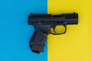 çok renkli bir arka plan üzerinde tabanca yakın görüntü . Eğlenceli bir sarı ve mavi arka plan üzerinde siyah silah.