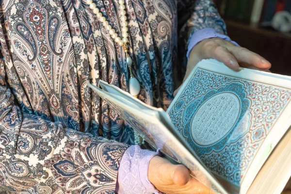 Eine ältere Frau hält den Koran in ihren Händen. Hände eines älteren Menschen mit einem heiligen Buch in Großaufnahme. Religiöses Konzept. namaz — Stockfoto