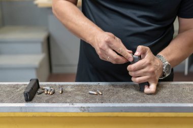 Kartuş. Adamların elleri silahı mühimmatla şarj etti. Close.