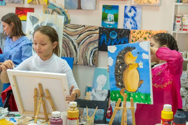 Rusia, Tartaristán, 20 de abril de 2019. La chica dibuja un erizo. Chica adolescente creativa paitning una imagen en caballete. Interior de la escuela de arte para dibujar niños. Concepto de creatividad y personas . —  Fotos de Stock