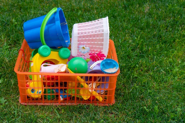 Çocuklar için gelişimsel oyun kavramı. Yeşil çim alanında çocuk oyuncakları, yeşil çim çocuk oyuncak kutusu. Seçici odak — Stok fotoğraf