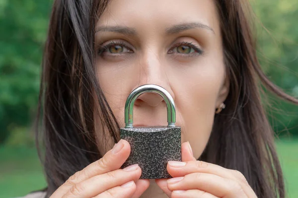 Conceptual portrait of a woman keeping silence with lock over her mouth. caucasian woman keep mouth locked. Language barrier concept and protecting the rights of women