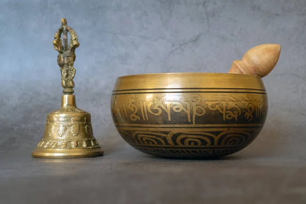 Singing bowl and golden bell close-up, soothing and meditative.