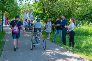 Rusya, Kazan - 31 Mayıs 2019: Bisikletli Down Sendromlu bir çocuk güneşli bir yaz gününde babasıyla birlikte bisiklet yarışına katılıyor