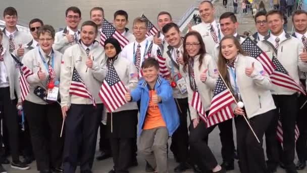 Russie, Kazan - 27 août 2019 : Un groupe de participants au Championnat d'Amérique avec des fans russes dans la zone fan pendant le WorldSkills Kazan 2019. Étudiants des États-Unis avec des drapeaux posant  . — Video