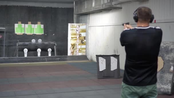Oroszország, Tatarstan, június 23, 2019. Az ember a lőtéren a forgatás fellépés Glock 19, Kilátás hátulról o kezében egy pisztolyt figyelembe célja távol a kamera sekély mélységélesség. — Stock videók