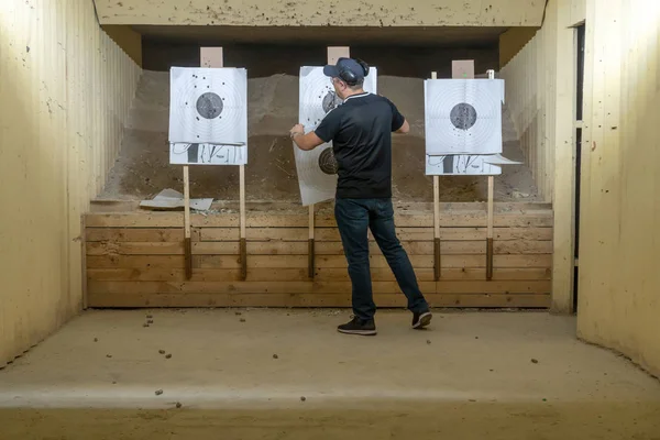 Bir adam tetikçi bir çizgi üzerinde bir kağıt hedef asılı — Stok fotoğraf