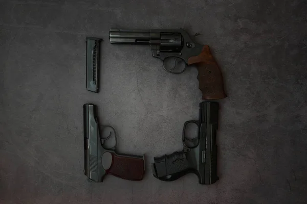 Arme à feu plat posé sur un fond gris. Pistolets pistolet sont disposés dans un cadre carré. espace de copie . — Photo