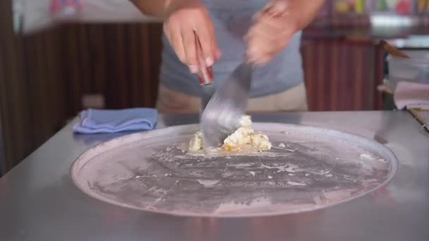 Cocinar helado de frutas naturales al estilo tailandés. Clip. Hacer rollos de helado con fruta de la pasión en el plato frío. Helado laminado, postre de helado hecho a mano. — Vídeo de stock