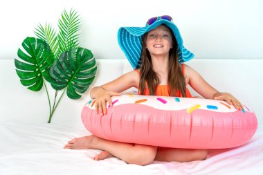 Küçük kız ev karantinasında tatil taklidi yapıyor. Ev turizmi. Turizm sektöründe Coronavirus durumu. Karantinaya alın. Evde kal. Tecrit. 