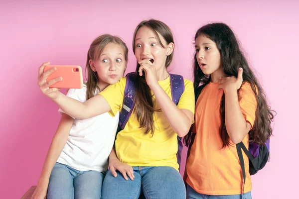 Tiga gadis remaja tersenyum dan merekam video dengan latar belakang merah muda. Selfie — Stok Foto