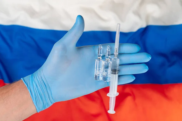 Vaccine and syringe injection. For prevention, immunization and treatment from corona virus infection novel coronavirus disease 2019, Covid-19 . Russia Flag background. Russia, Kazan - August 14, 2020.