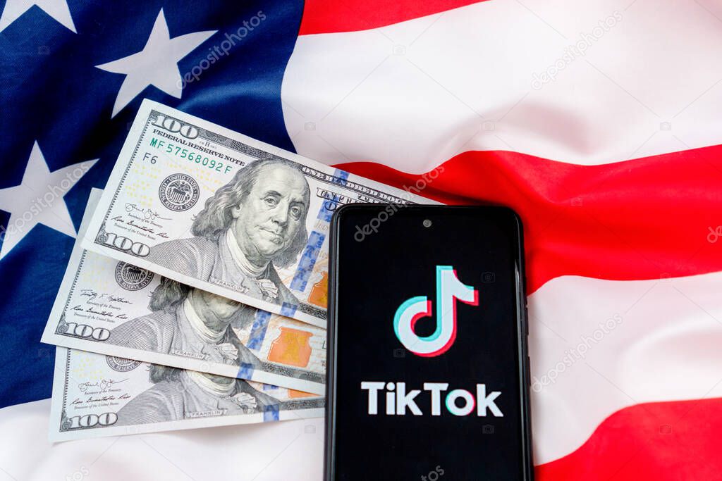 Tiktok application logo on a smartphone with American flag background. Donald Trump to ban Tiktok in United States. Russia, Kazan - August 08, 2020