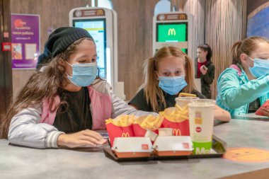 Maskeli çocuklar McDonalds 'da oturuyor. Rusya, Tataristan, 20 Eylül 2020.