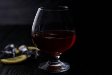 Buz ve limon ile ahşap bir arka plan üzerinde bir bardak konyak