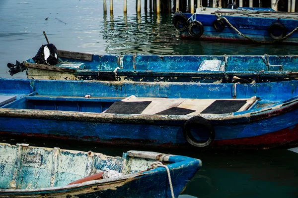 Floating wooden boats near a floating village in Malaysia.Old wooden boats used for fishing by villagers, close-up