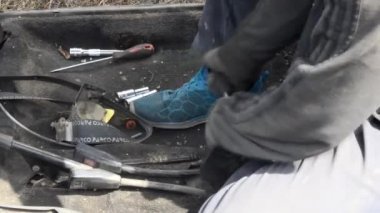 Eski bir arabada çalışan adam, tamirci.