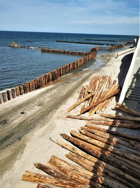 Mare Blu Con Frangiflutti Legno Tronchi Vicini Raccolti — Foto Stock