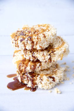 Eski beyaz ahşap masadaki cam şişede karamelli pilav, tatlı Tayland gevreği, Tayland tatlısı.jpg