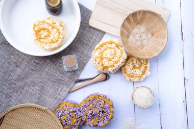 Eski beyaz ahşap masadaki cam şişede karamelli pilav, tatlı Tayland gevreği, Tayland tatlısı.jpg